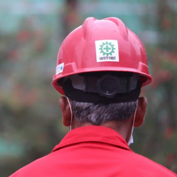 A man wearing a red shirt and hard hat.