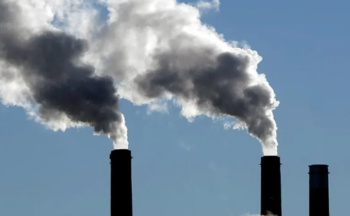 Pollution clouds streaming into a blue sky.