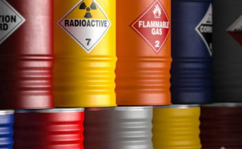 A close up of barrels with stickers that say "radioactive" and "flammable gas"