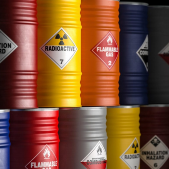 A close up of barrels with stickers that say "radioactive" and "flammable gas"