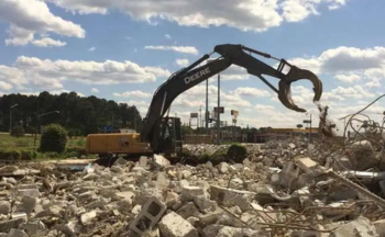 A crane moving debris at a construction site.