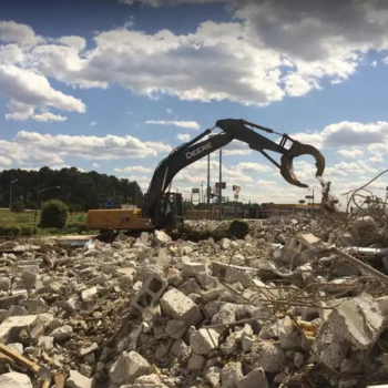 A crane moving debris at a construction site.