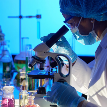 A scientist looking into a microscope.