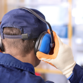 A worker adjusts his hearing protection gear.