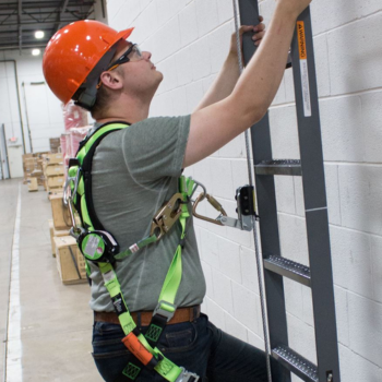 A worker climbing a ladder inside a warehouse.