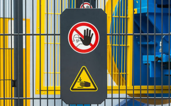 A machine guard that has an icon indicating people should not put their hands through the bars.
