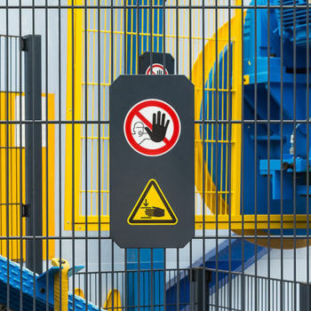 A machine guard that has an icon indicating people should not put their hands through the bars.
